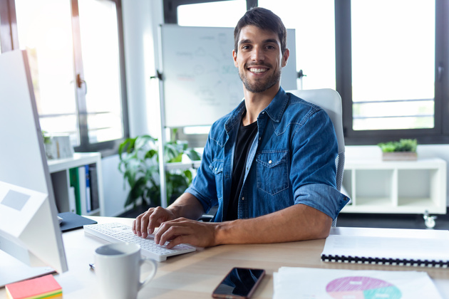 Happy male employee working in his computer
